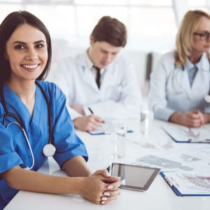 Doctors sitting at table looking happy because they receive above average wage