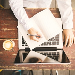 man seated at a computer typing up his resume for a job