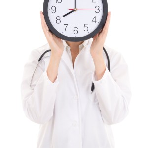 Nurse holding a clock in front of her face