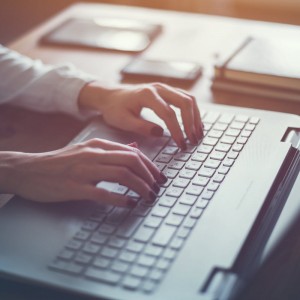 a nurse typing a cover letter on her laptop