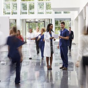 A doctor and nurse standing in the hallway of a hospital