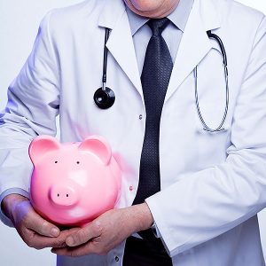Doctor holding a piggy bank to indicate earnings