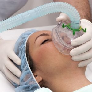 Anaesthetist placing mask over patient