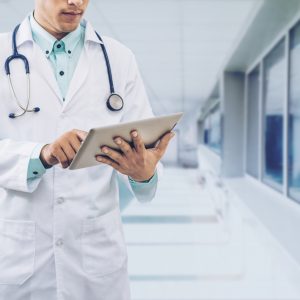 Male Doctor Working On Tablet Computer