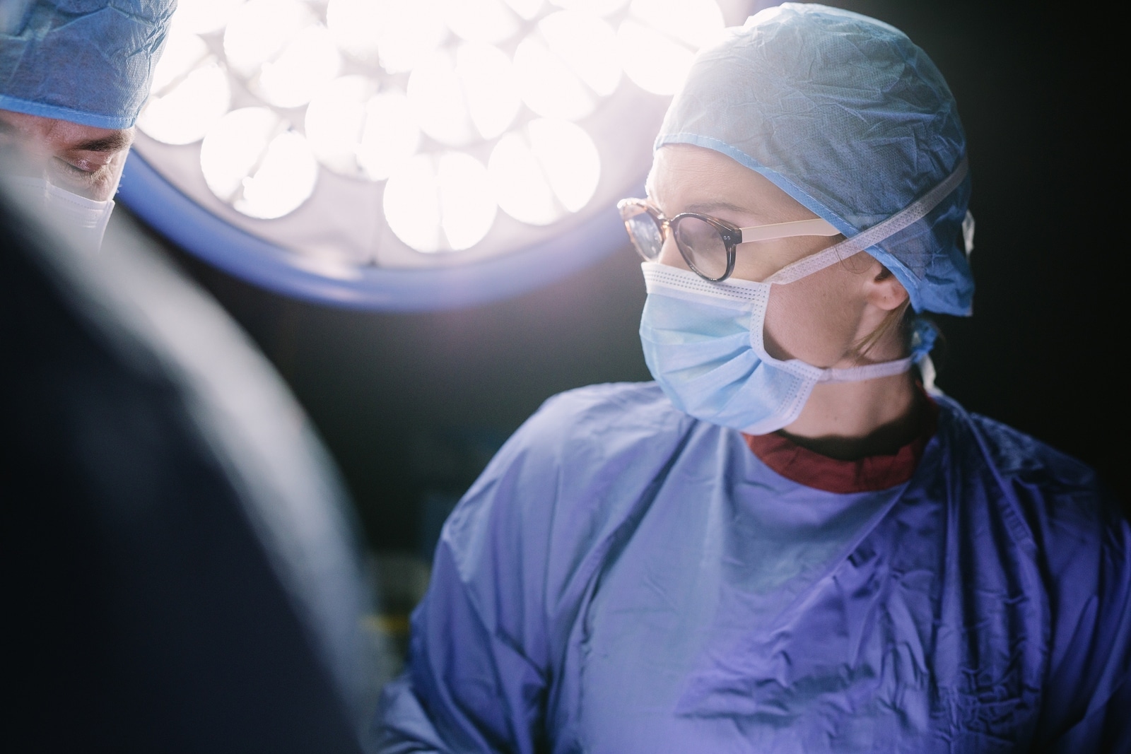 Concentrated surgeon performing surgery with her team in hospital operating room. Medics during surgery in operation theatre.