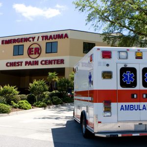 An ambulance pulls into a modern hospital emergency room entrance.