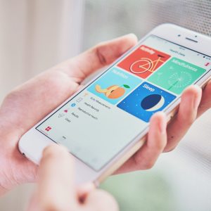 women holding smartphone on the Health app screen which monitors the fitness data of the user.