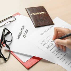 Woman filling urgent passport application form at table. Immigration and citizenship