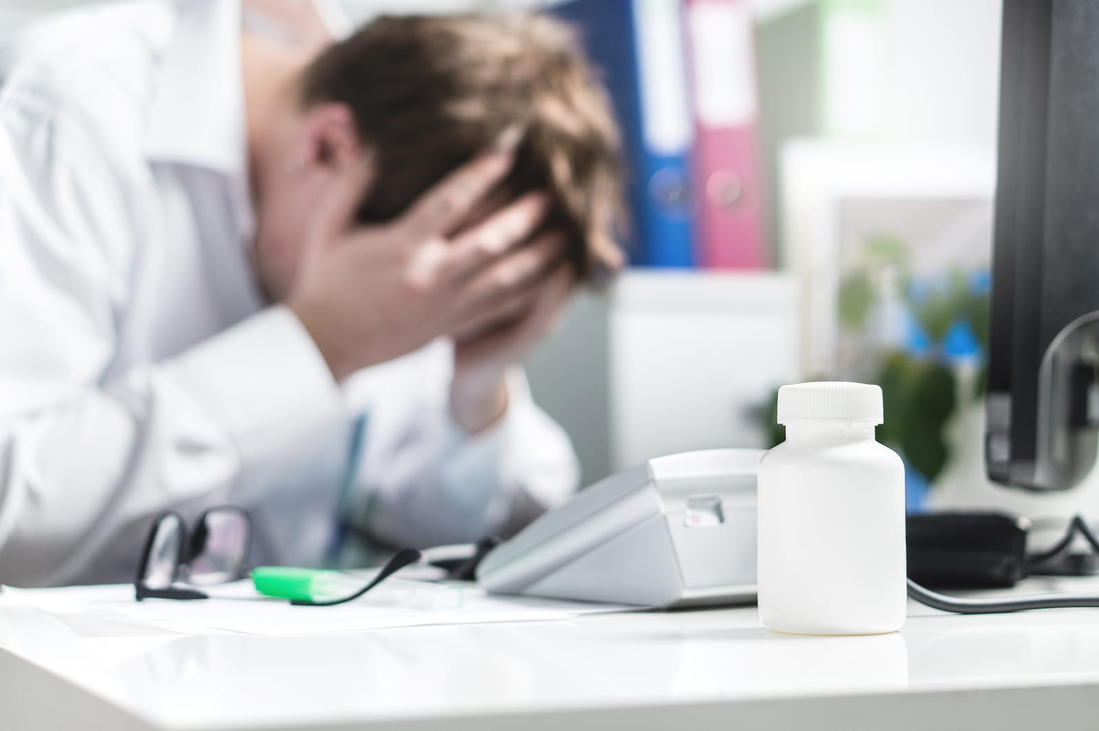 unhappy doctor cover face in hospital office. 