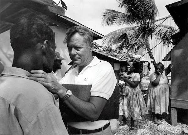 A doctor examining a farmer in a rural village